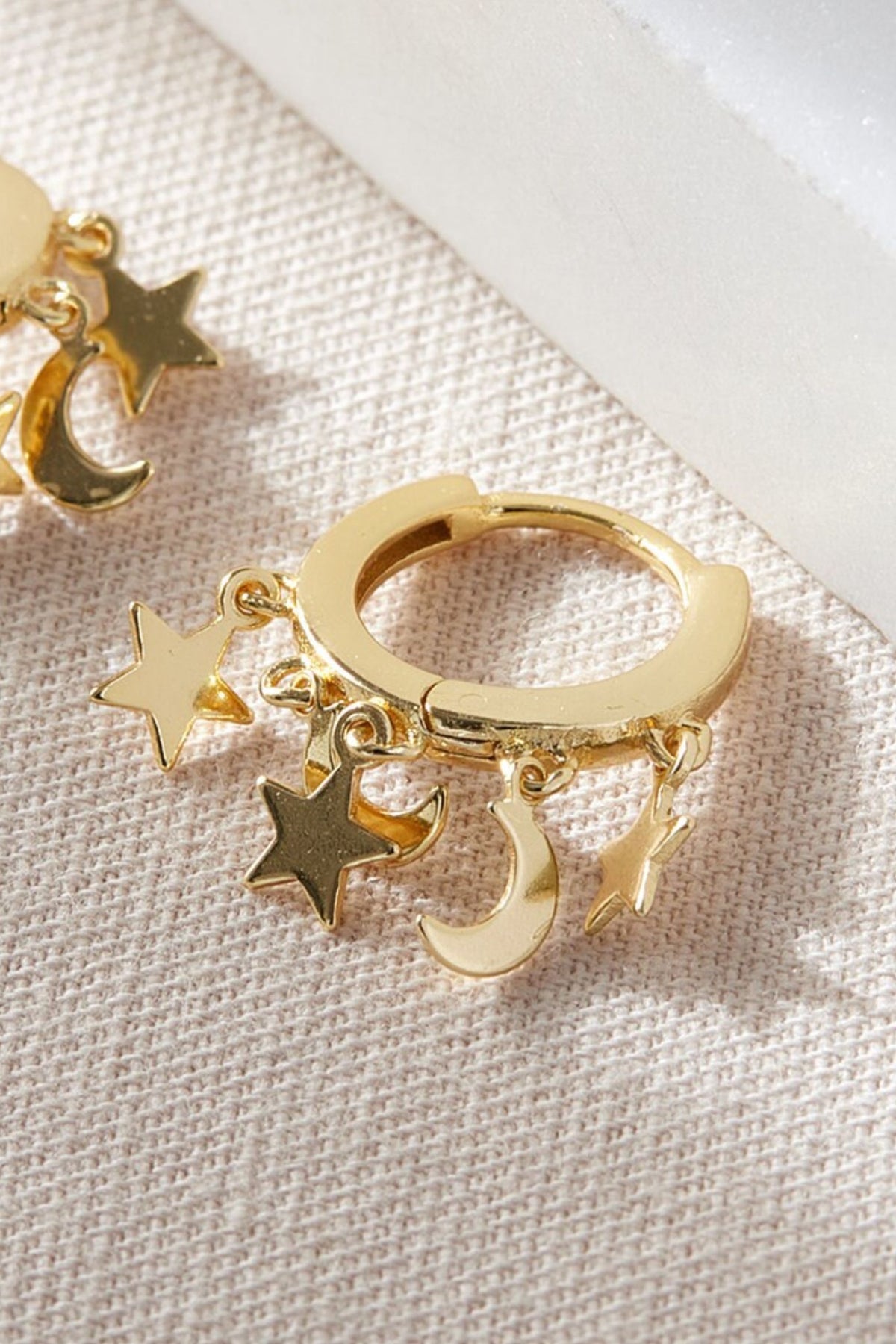 sterling-silver-star-moon-charm-hoops-in-gold-closeup
