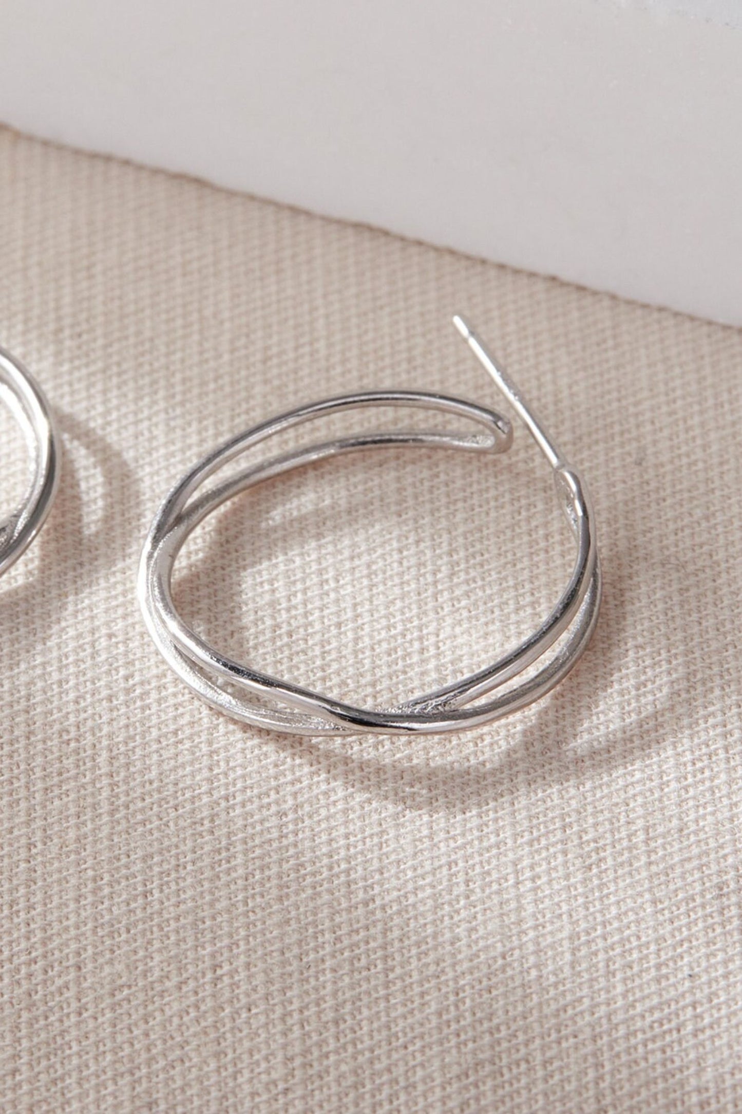 sterling-silver-wave-twist-hoops-23mm-in-silver-closeup