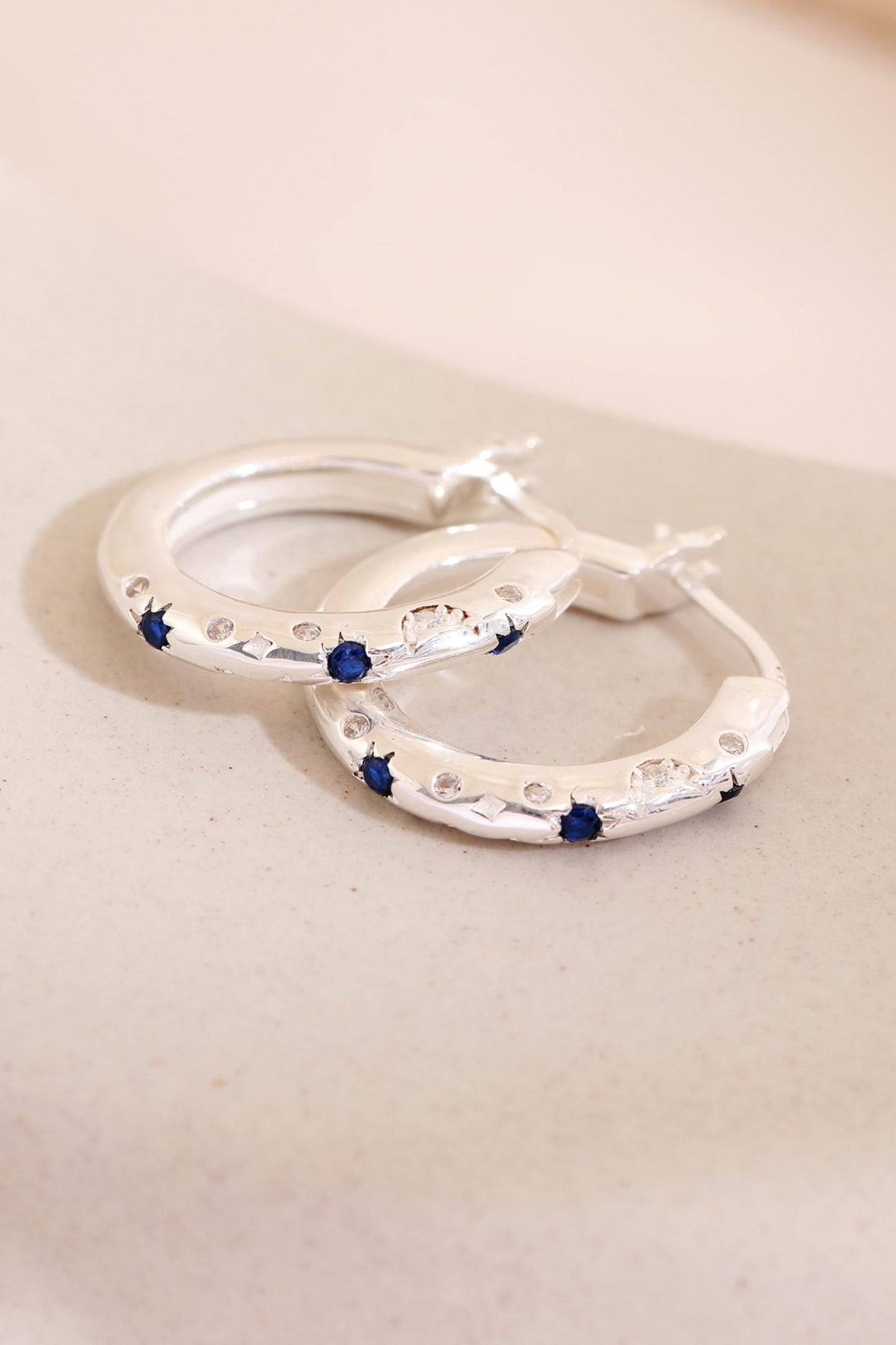 sterling-silver-engraved-celestial-hoops-in-silver-lying-flat