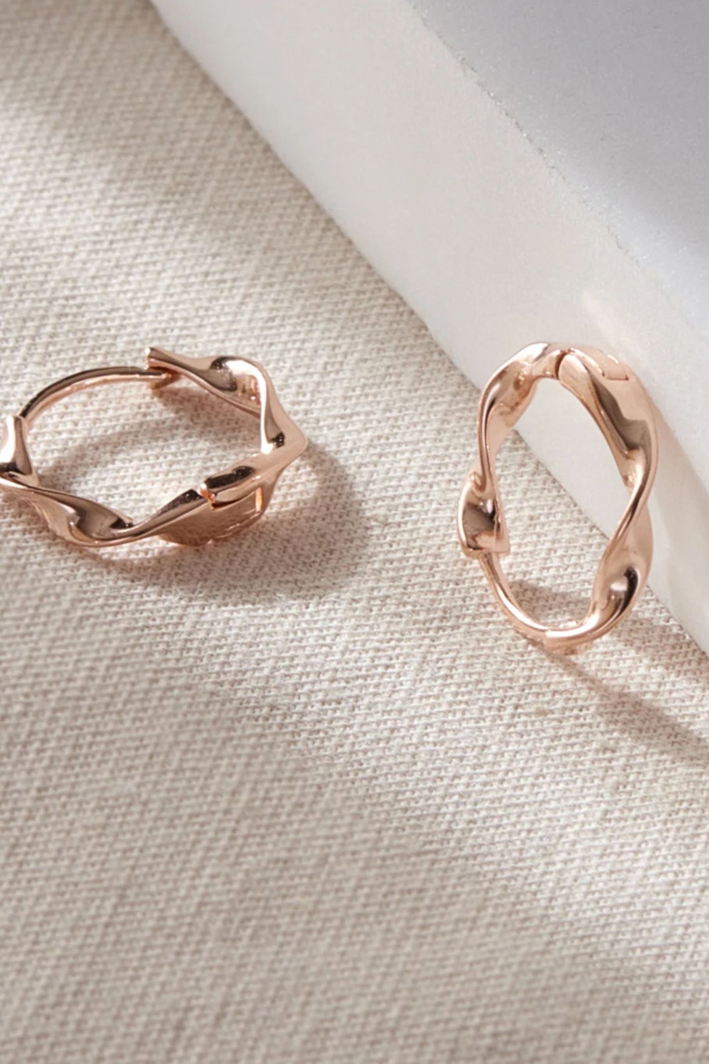 sterling-silver-minimalist-twist-hoops-in-rose-gold-closeup