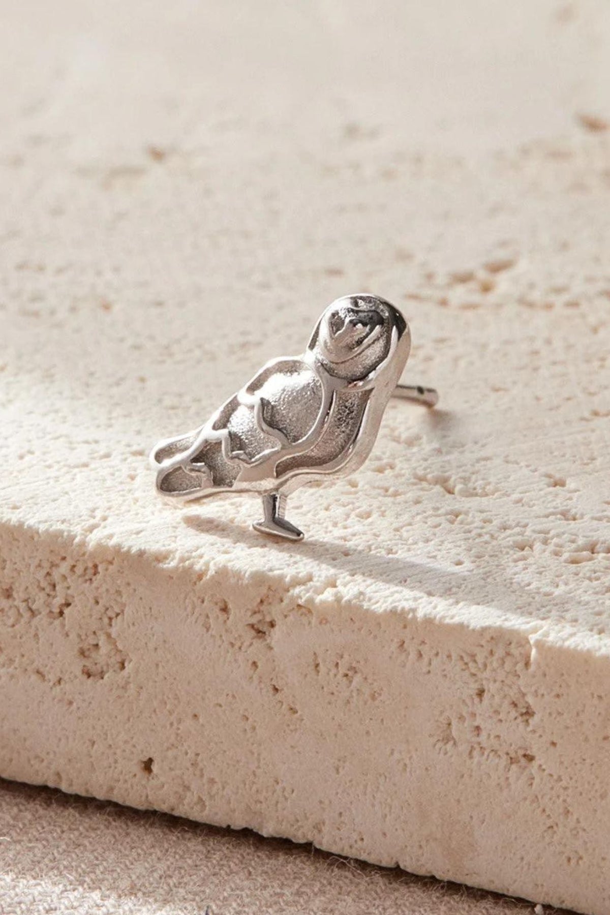 close up of the silver barn owl earring, showing the detail of the design