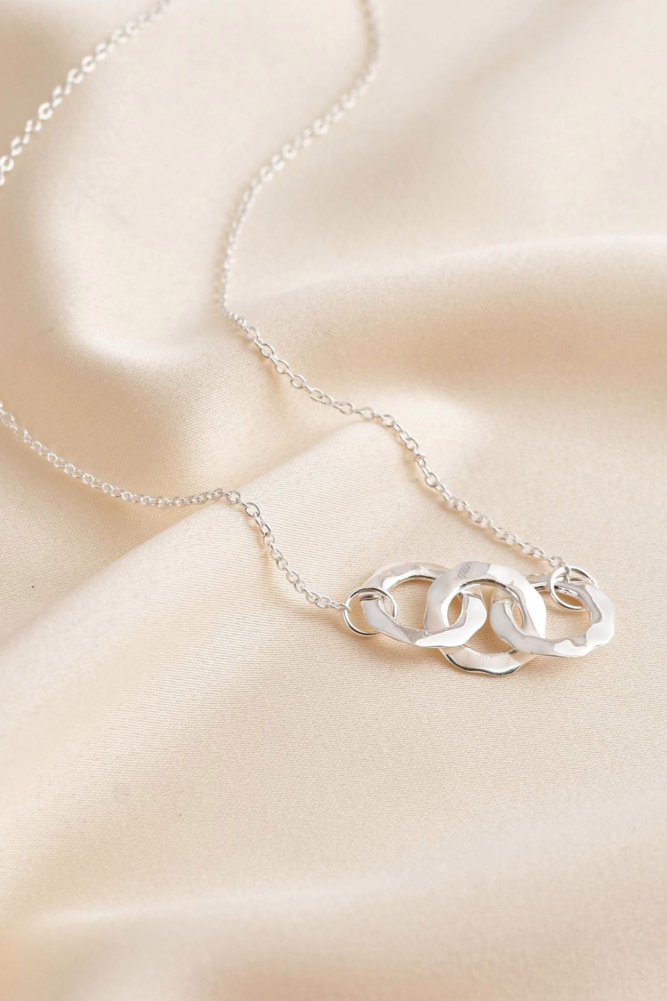 sterling-silver-hammered-triple-ring-necklace-lying-flat