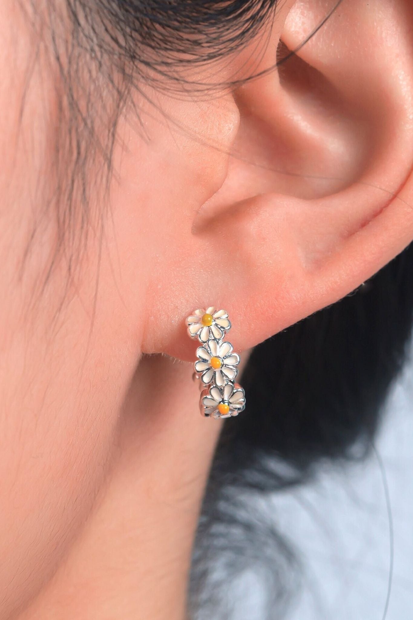 silver-daisy-huggie-hoops-model-earlobe