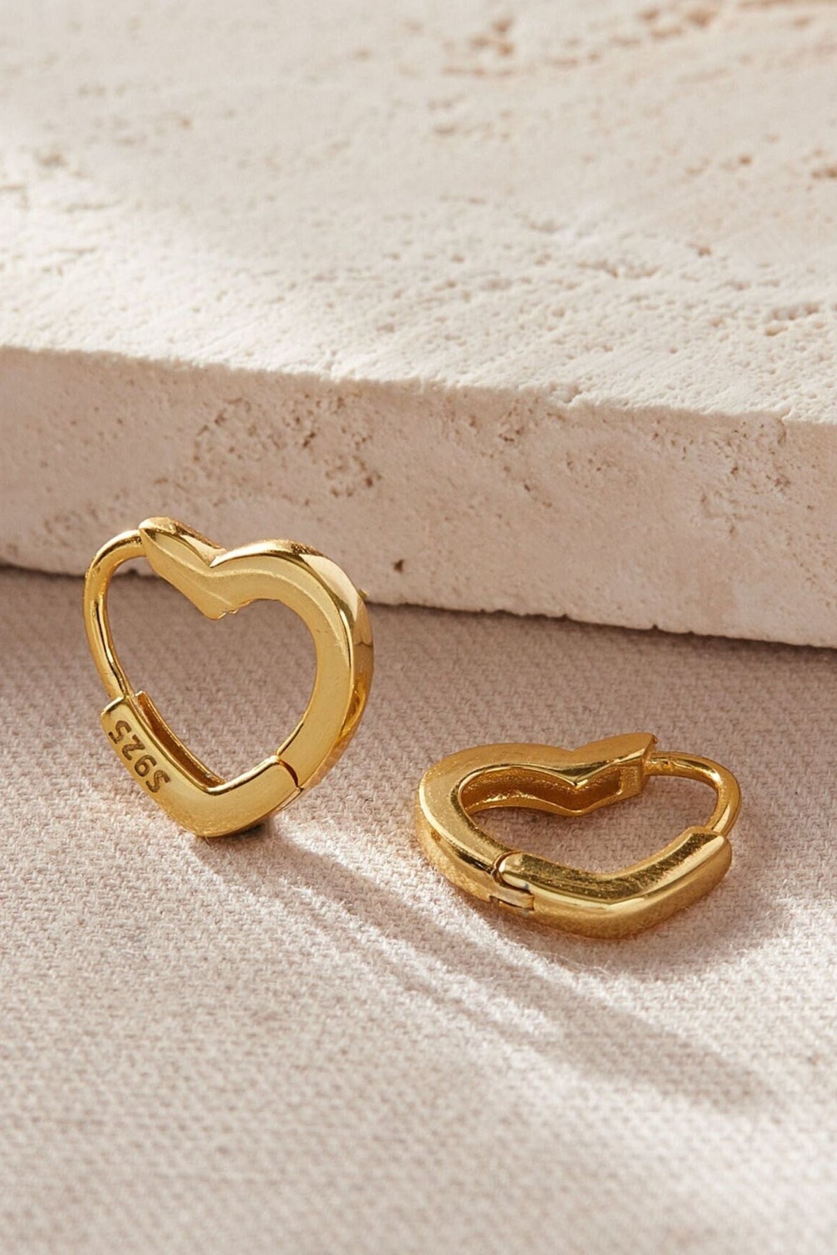 sterling-silver-heart-huggie-hoops-in-gold-closeup