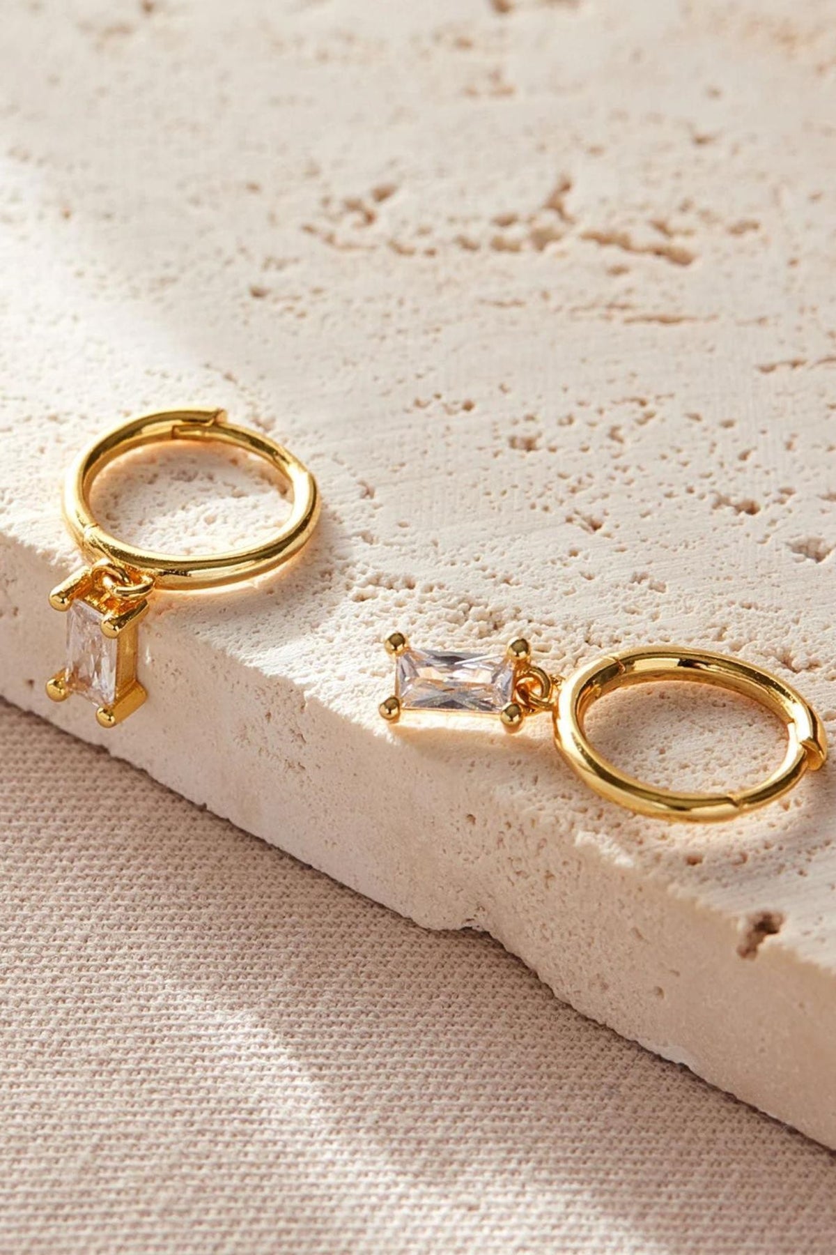 close up of the clear white cz gold dangle hoop earrings