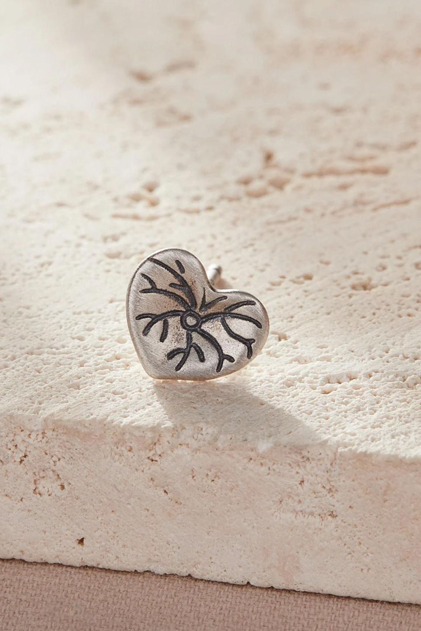 close up of the lily pad leaf earring, it is love heart shaped and detailed like a lily leaf