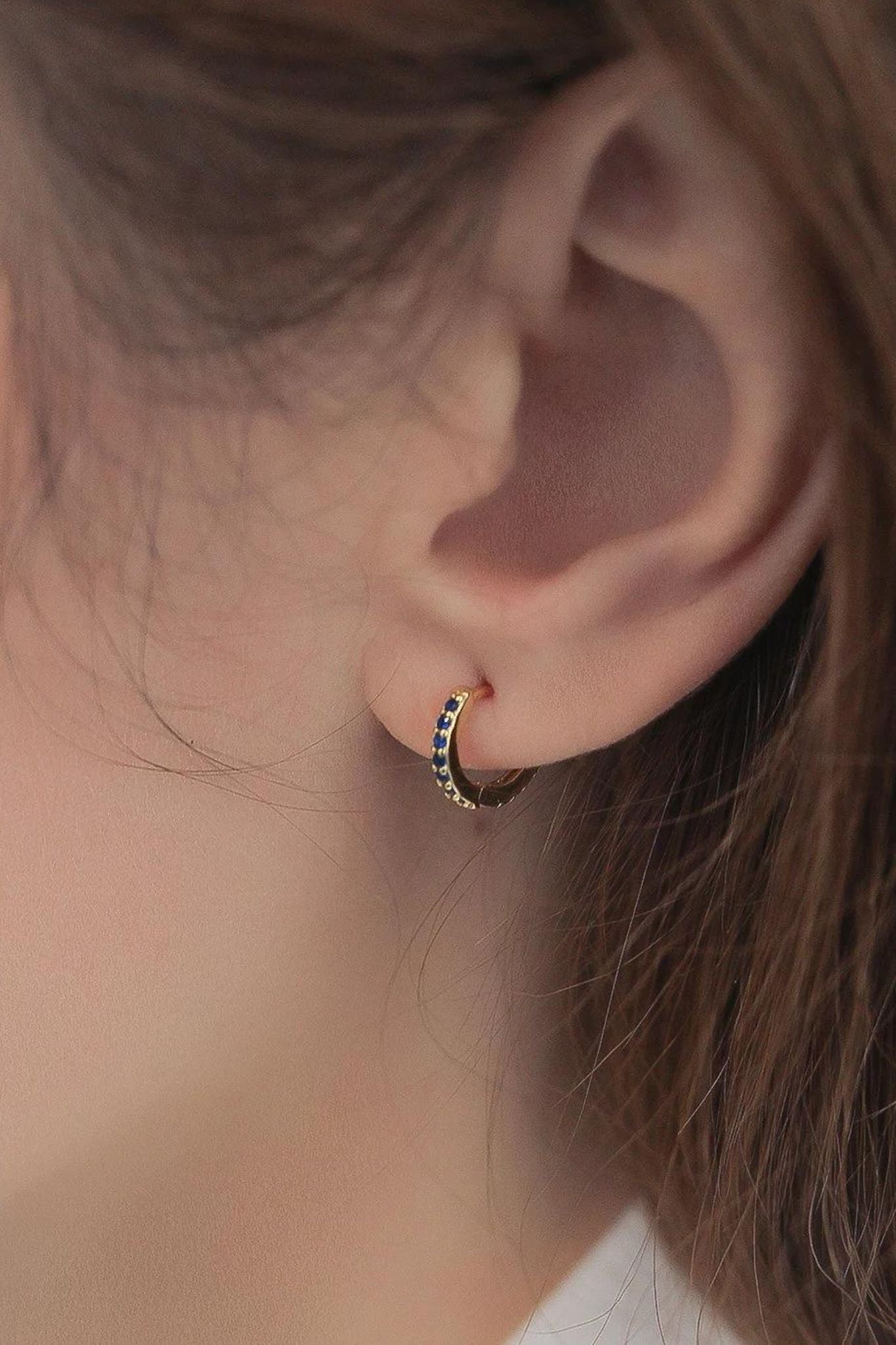 sterling-silver-cz-huggie-hoops-in-gold-blue-model