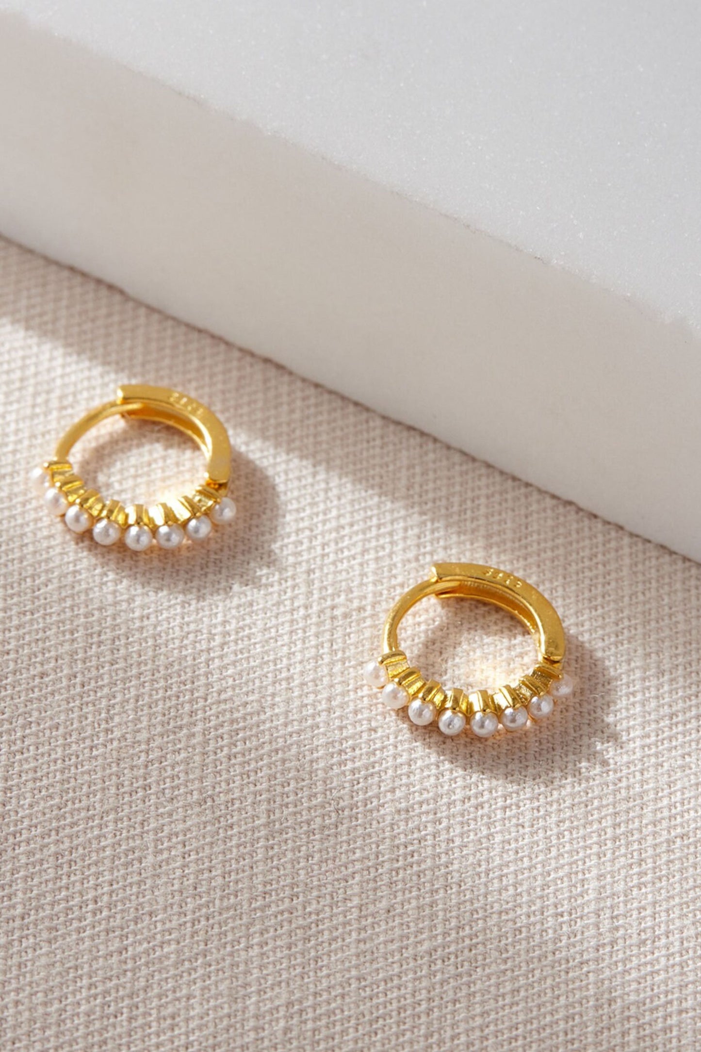 stirling-silver-pearl-beaded-huggie-hoops-in-gold-closeup