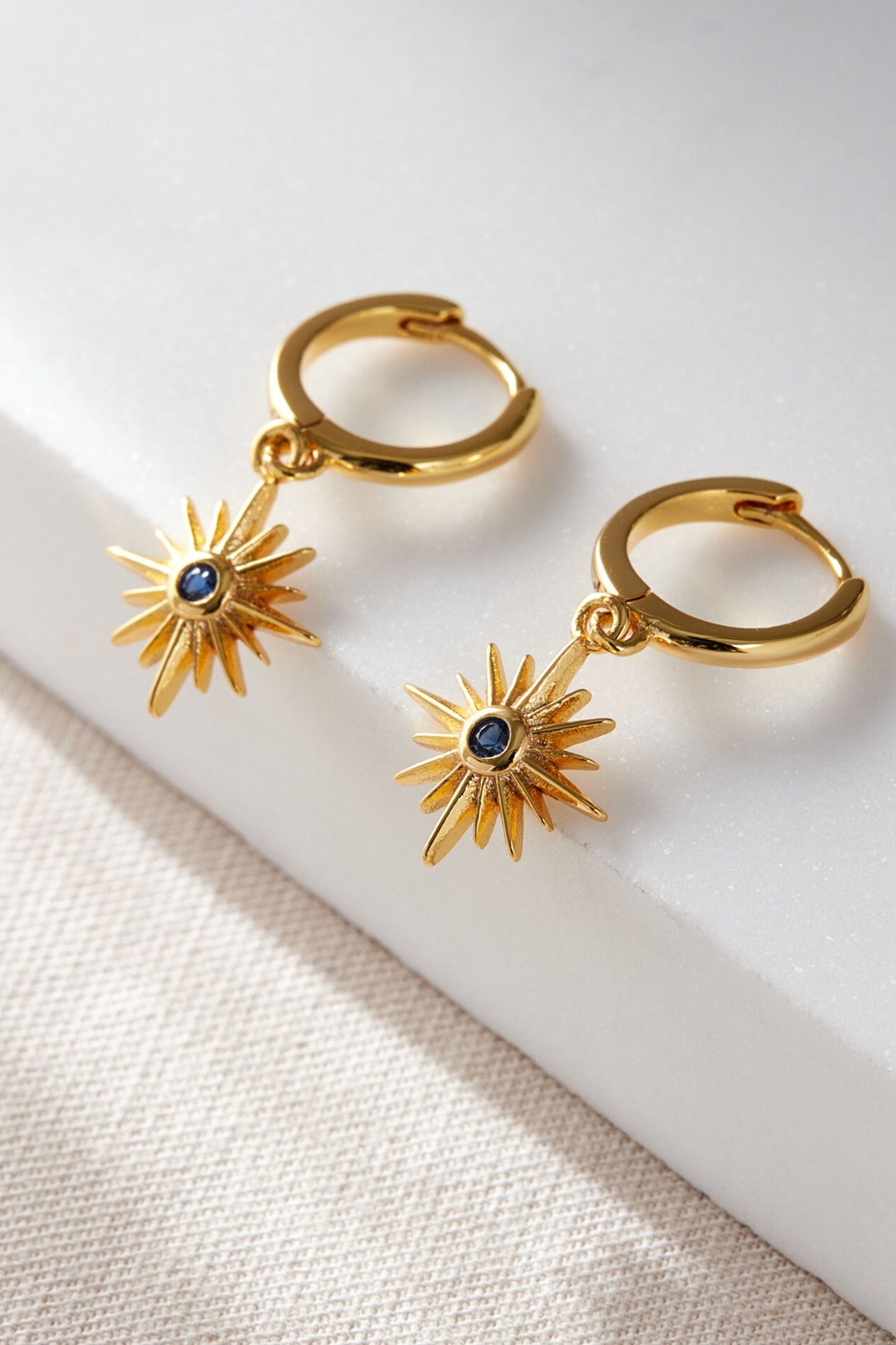 sterling-silver-north-star-hoops-in-gold-blue-closeup