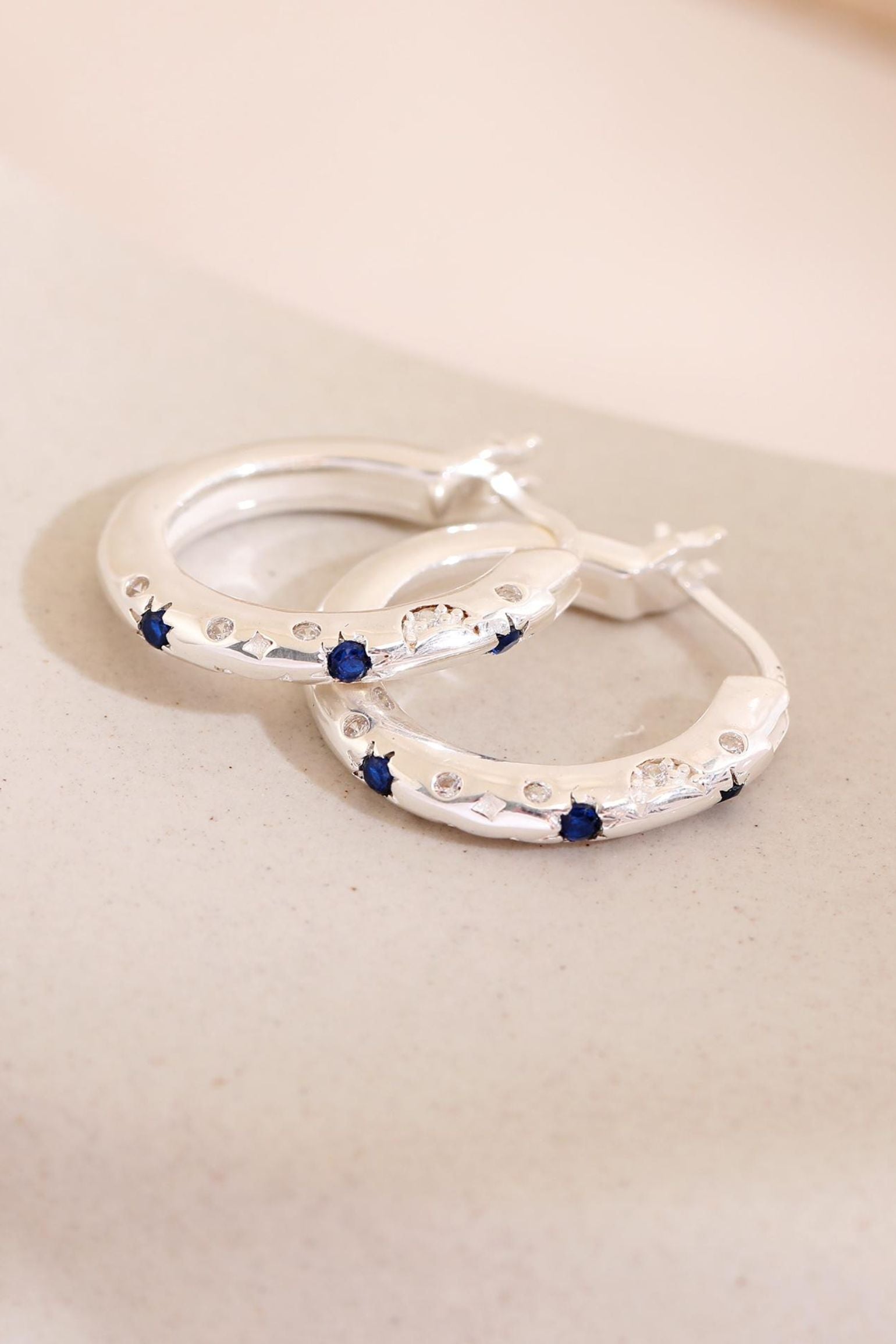 sterling-silver-engraved-celestial-hoops-in-silver-lying-flat
