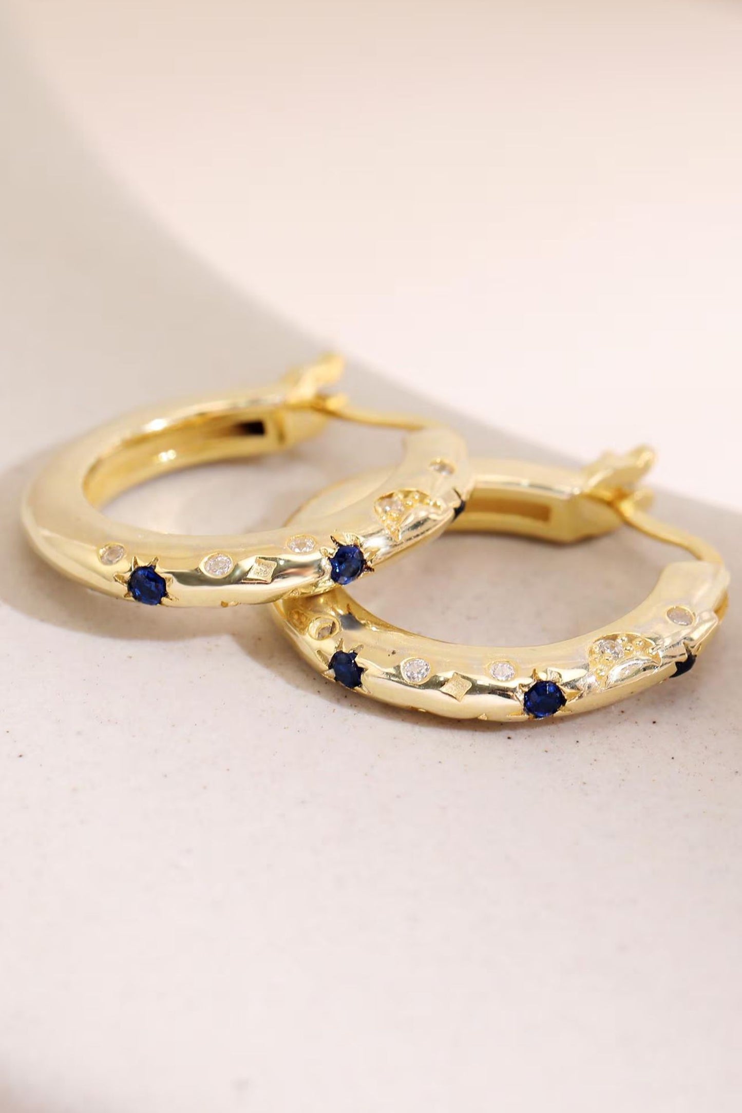 sterling-silver-engraved-celestial-hoops-in-gold-lying-flat