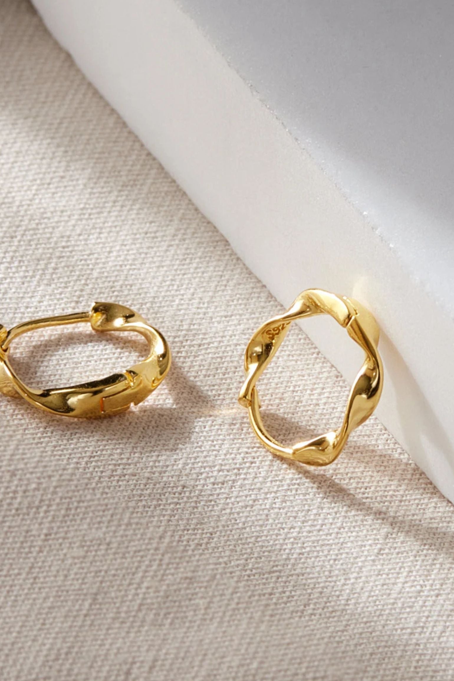sterling-silver-minimalist-twist-hoops-in-gold-closeup