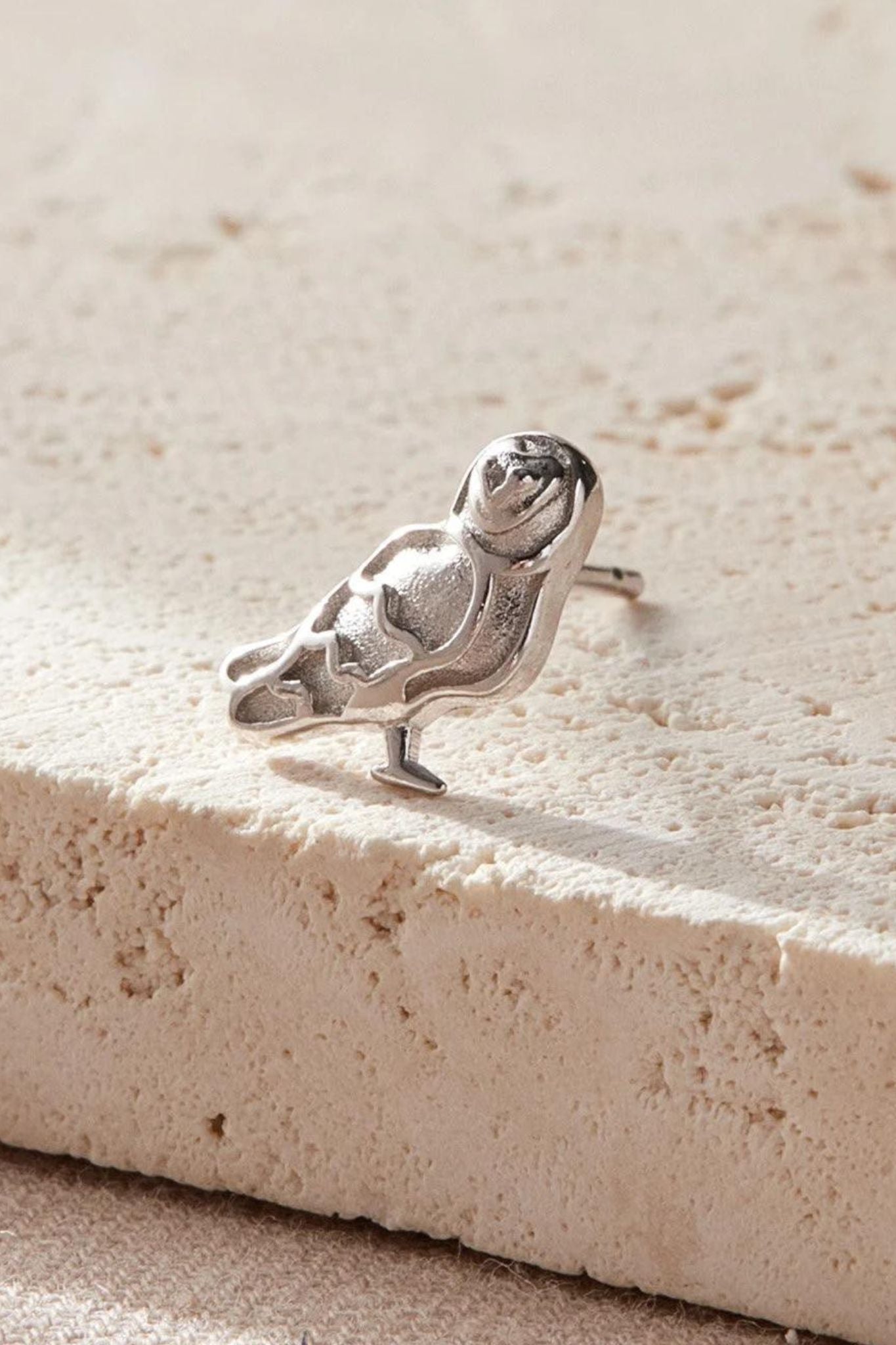 close up of the silver barn owl earring, showing the detail of the design 